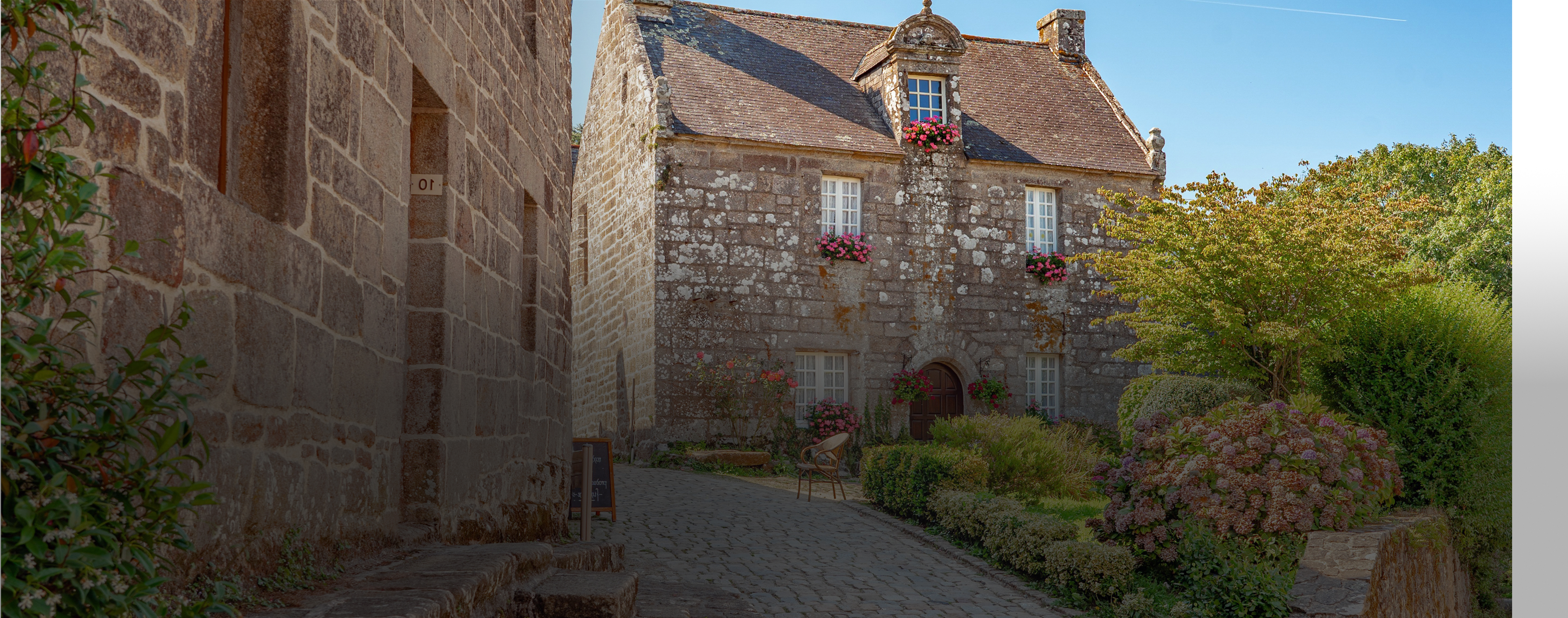 Beautiful french stone houses in a village with lush greenery and sunny sky